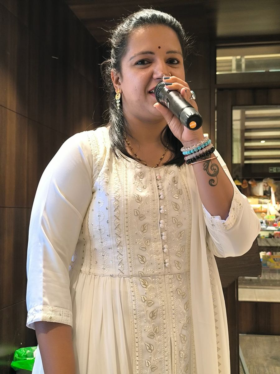Priya with karaoke setup and Priya Musical signage
