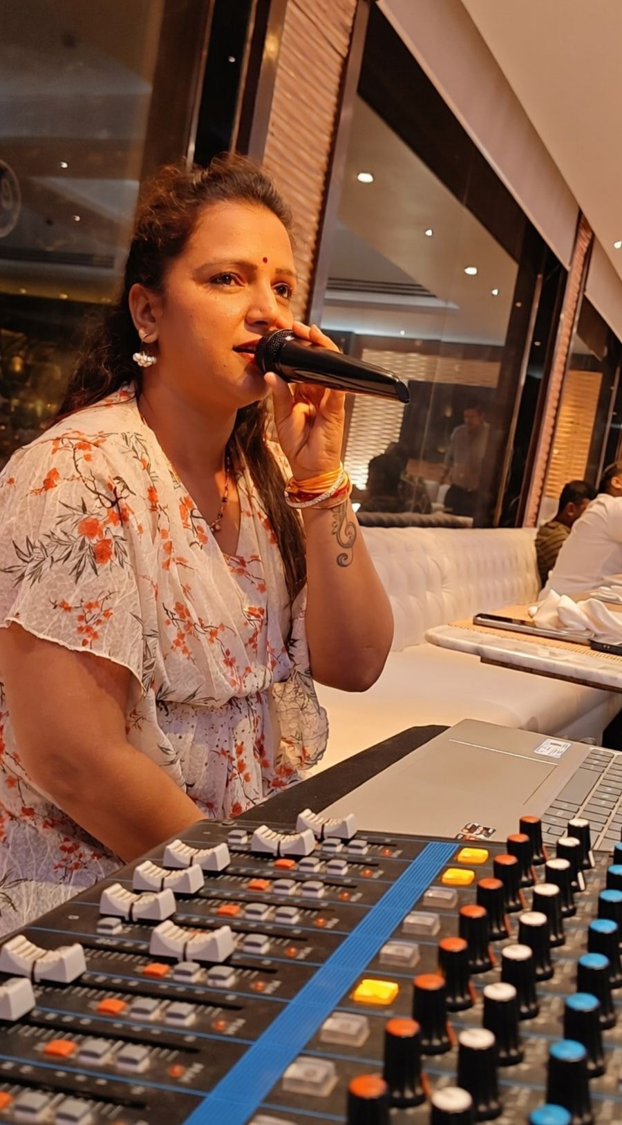 Priya performing near mixing console